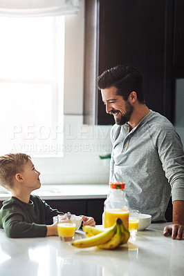 Buy stock photo Cropped shot of a handsome young man talking to his son while having breakfast
 in the kitchen