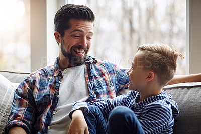 Buy stock photo Shot of a father and his little son bonding together at home