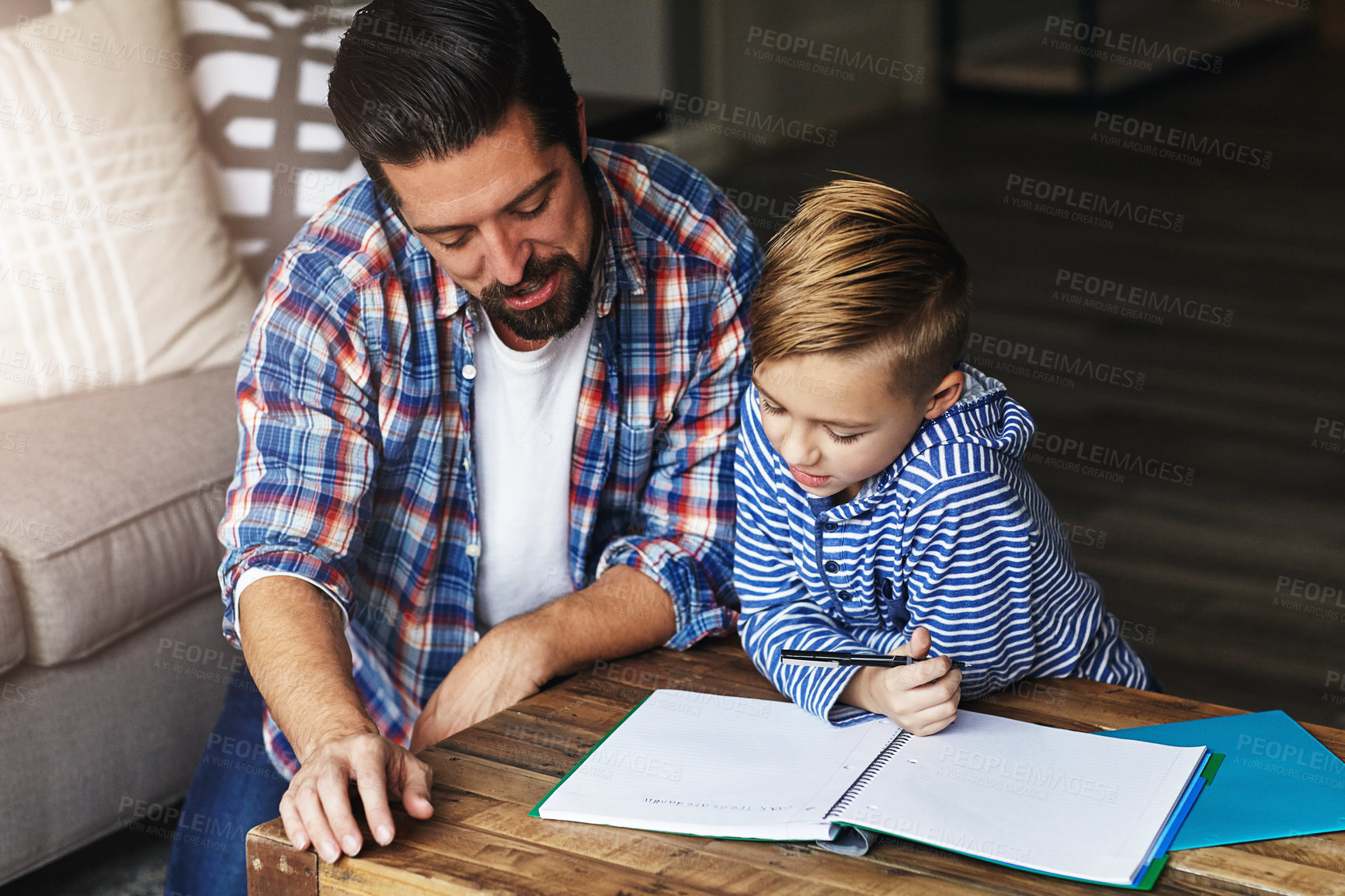 Buy stock photo Shot of a father helping his little son with his homework