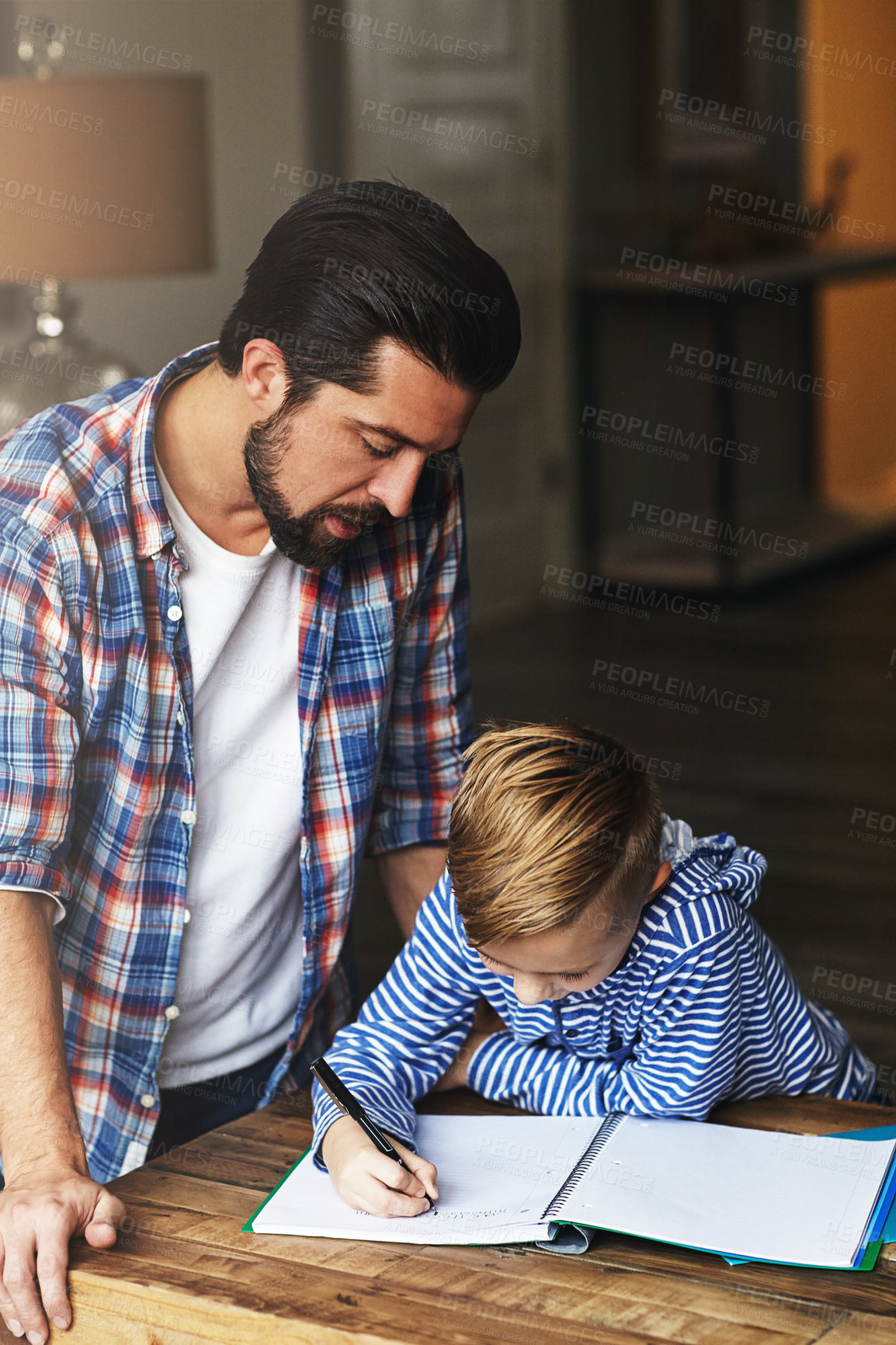 Buy stock photo Shot of a father helping his little son with his homework