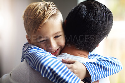 Buy stock photo Shot of an adorable little boy hugging his father at home