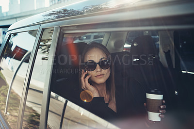 Buy stock photo Shot of a young businesswoman using a mobile phone while traveling in a car