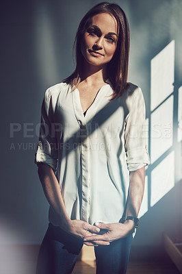 Buy stock photo Shot of a beautiful young businesswoman standing in a modern office