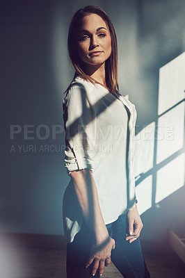 Buy stock photo Shot of a beautiful young businesswoman standing in a modern office