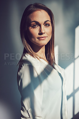Buy stock photo Shot of a beautiful young businesswoman standing in a modern office