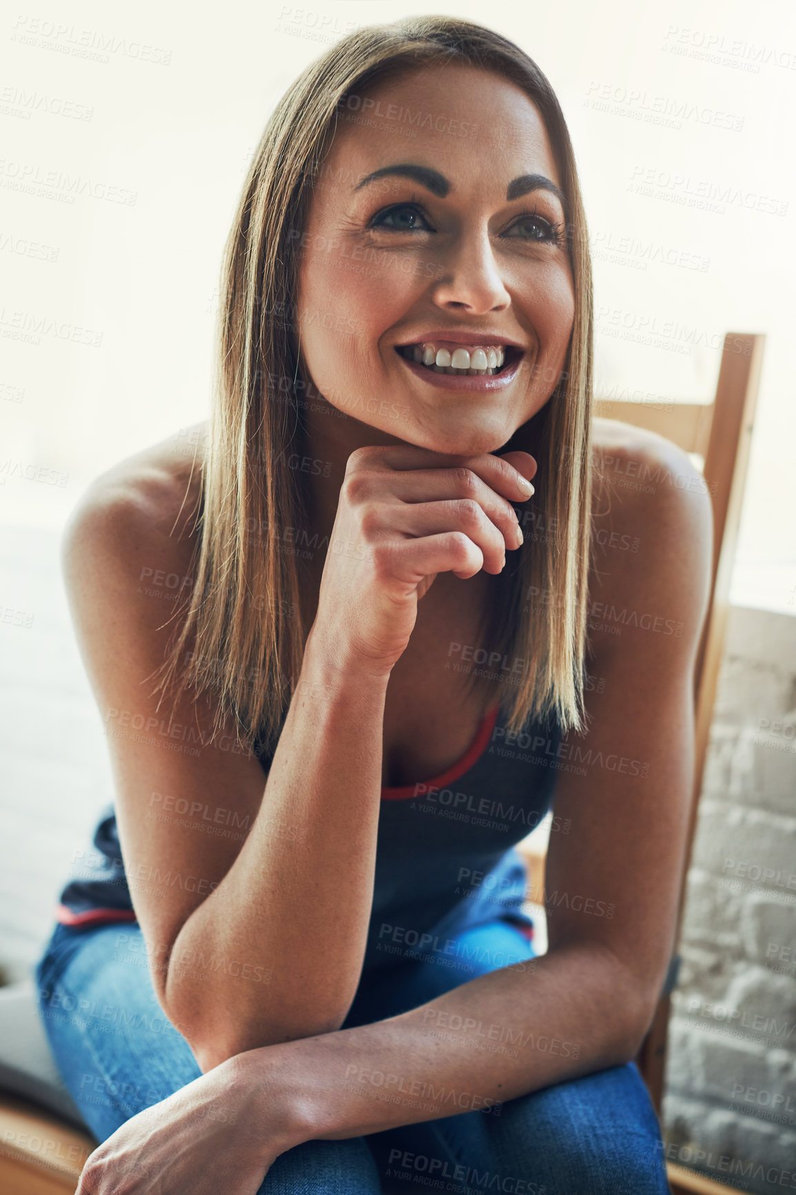 Buy stock photo Cropped shot of an attractive young sportswoman looking thoughtful while sitting on a wooden chair