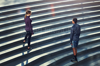 Buy stock photo High angle shot of two young sportspeople standing on stairs during their outdoor workout
