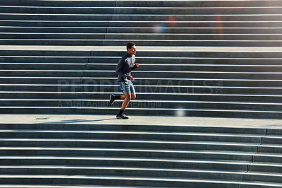 Buy stock photo Full length shot of a handsome young sportsman running up and down stairs outside