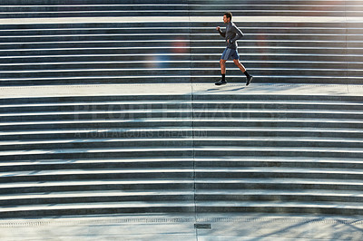 Buy stock photo Full length shot of a handsome young sportsman running up and down stairs outside