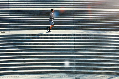 Buy stock photo Full length shot of a handsome young sportsman running up and down stairs outside