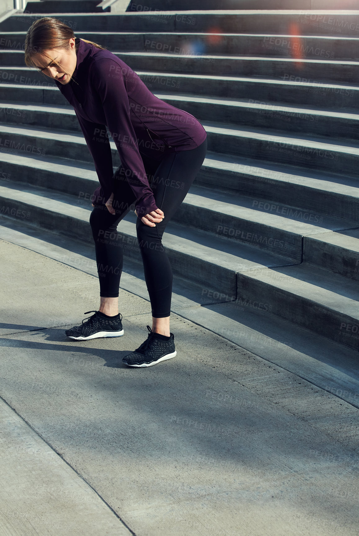 Buy stock photo Full length shot of an attractive young sportswoman resting after running up and down stairs outside