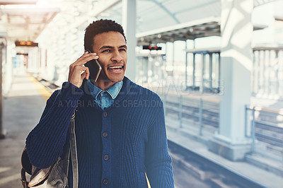 Buy stock photo Shot of a young businessman using a mobile phone while walking through the subway