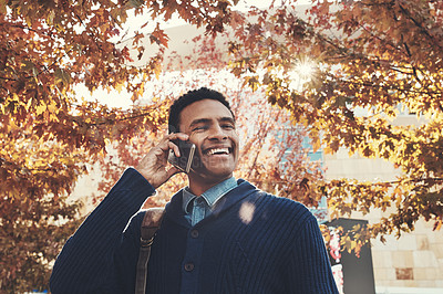 Buy stock photo Shot of a young businessman using a mobile phone while walking outdoors