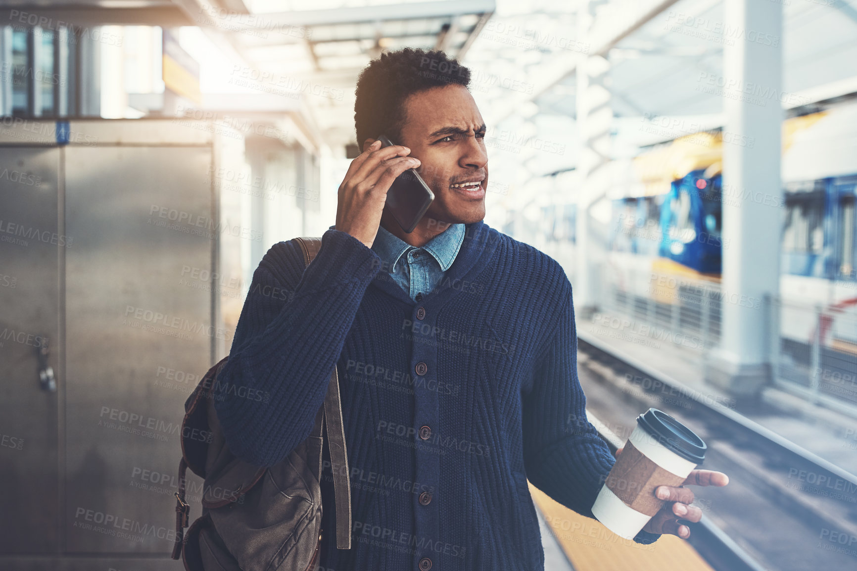 Buy stock photo Shot of a young businessman using a mobile phone while walking through the subway