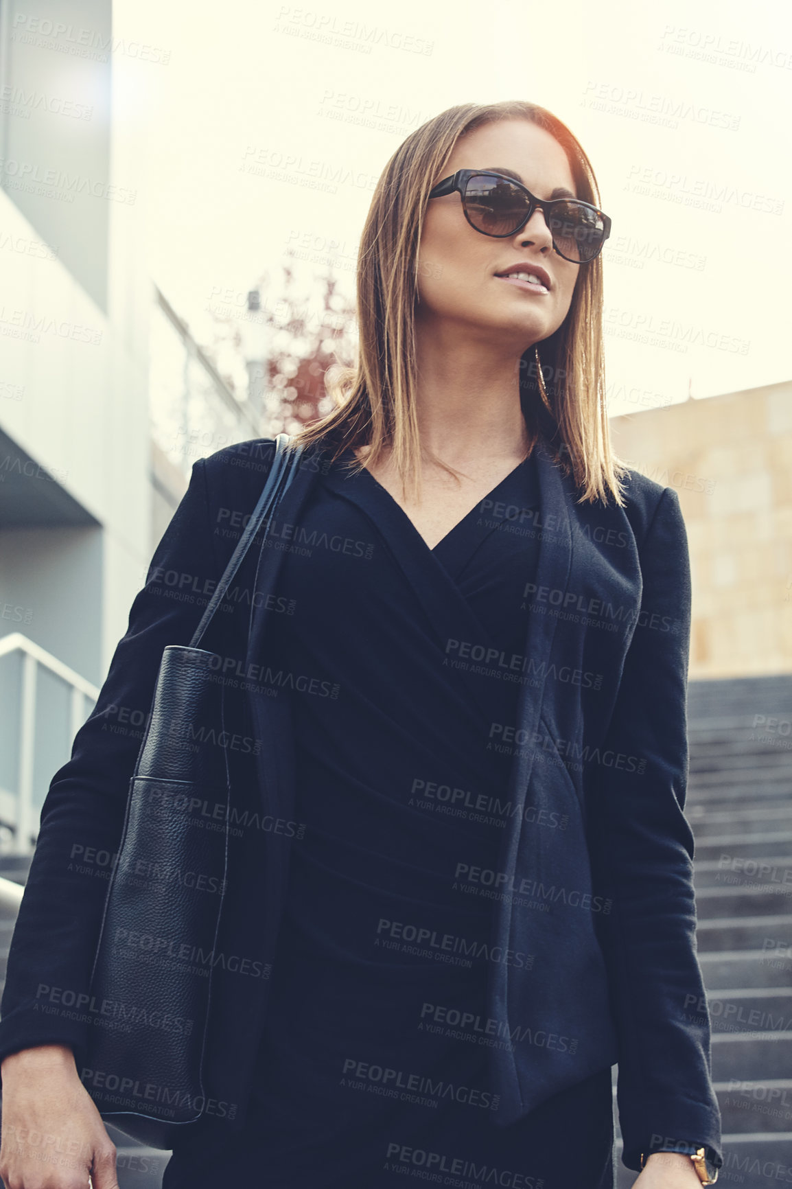 Buy stock photo Shot of a beautiful young businesswoman walking through the city