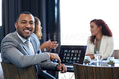 Buy stock photo Cropped portrait of a handsome young businessman sitting in the boardroom during a meeting