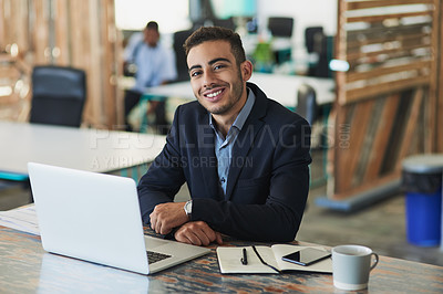 Buy stock photo Portrait of a young businessman working on a laptop in an office