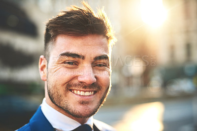 Buy stock photo Portrait of a cheerful young businessman standing in the busy streets of the city in the morning