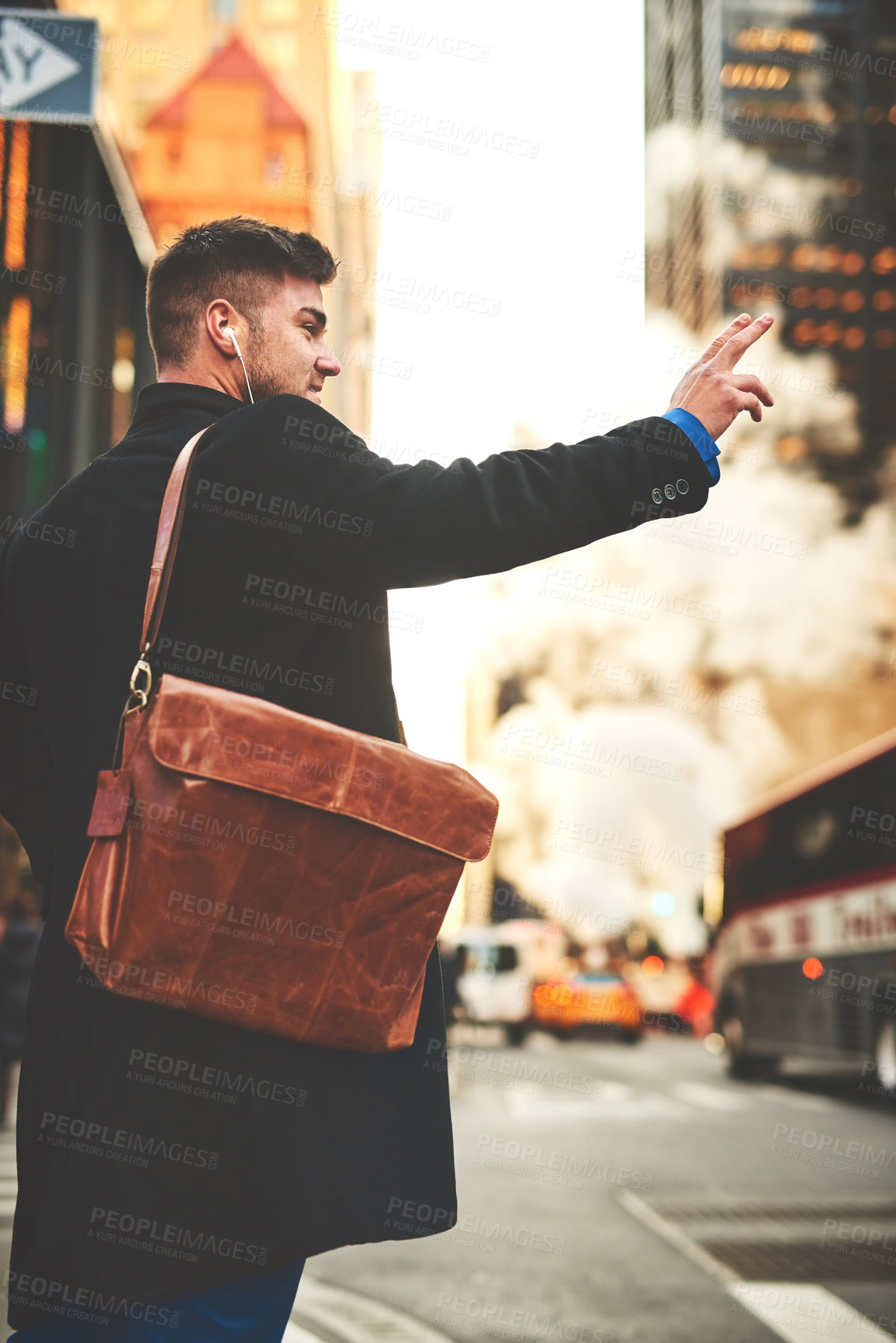Buy stock photo Shot of a cheerful young man listening to music while he tries to signal a taxi to get to work in the busy streets of the city