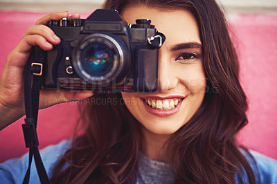 Buy stock photo Portrait of a beautiful young woman holding a dslr camera and posing against a wall outside