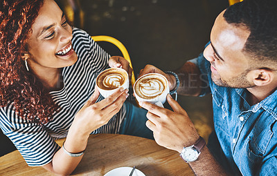 Buy stock photo High angle shot of an affectionate young couple sitting in a coffee shop