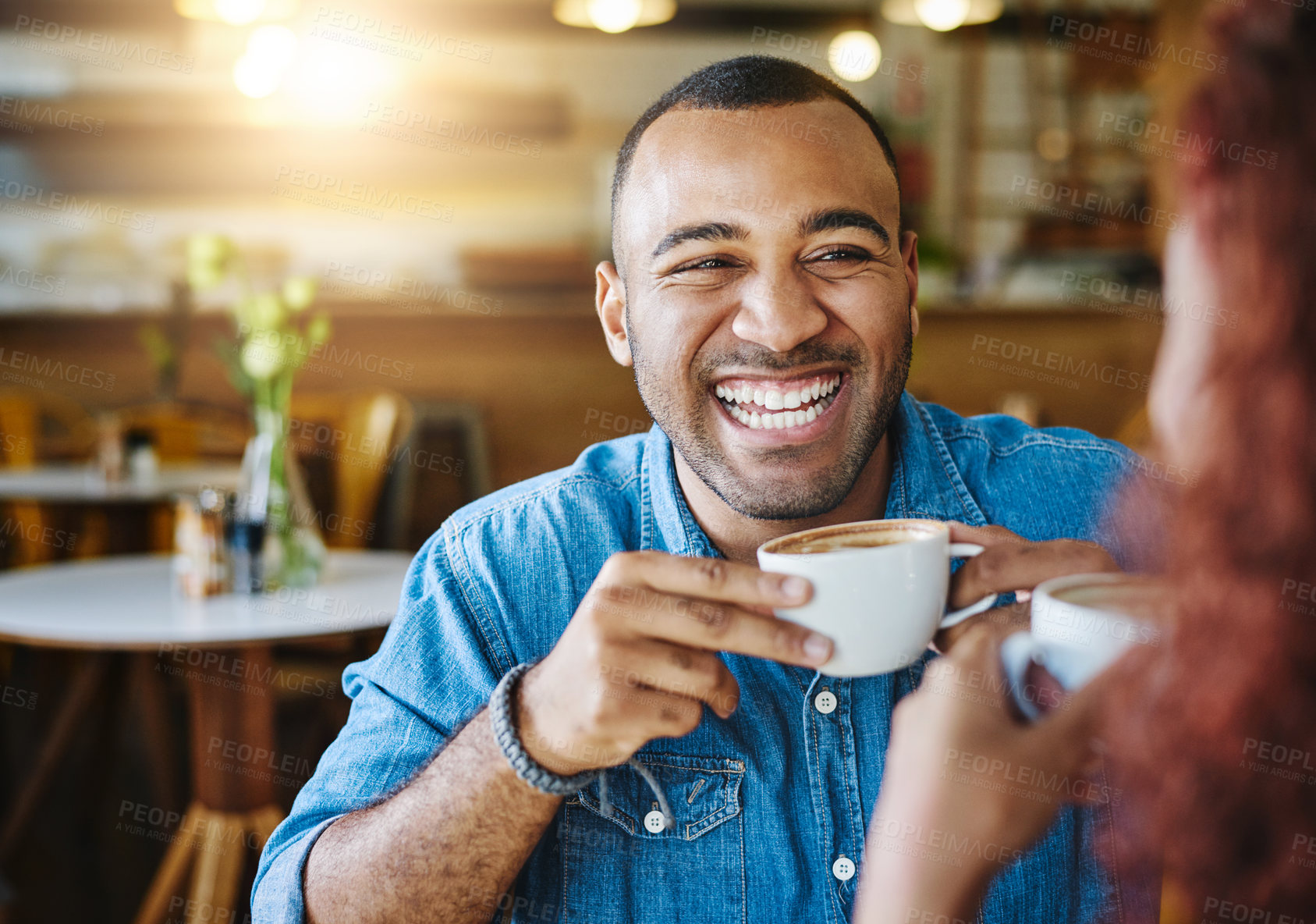 Buy stock photo Cropped shot of a handsome young man spending time with his girlfriend in a coffee shop