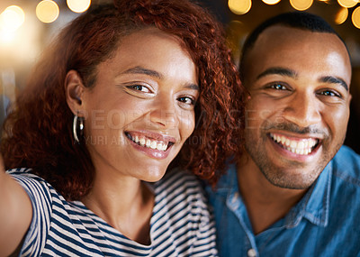 Buy stock photo Cropped shot of an affectionate young couple taking selfies while sitting in a coffee shop