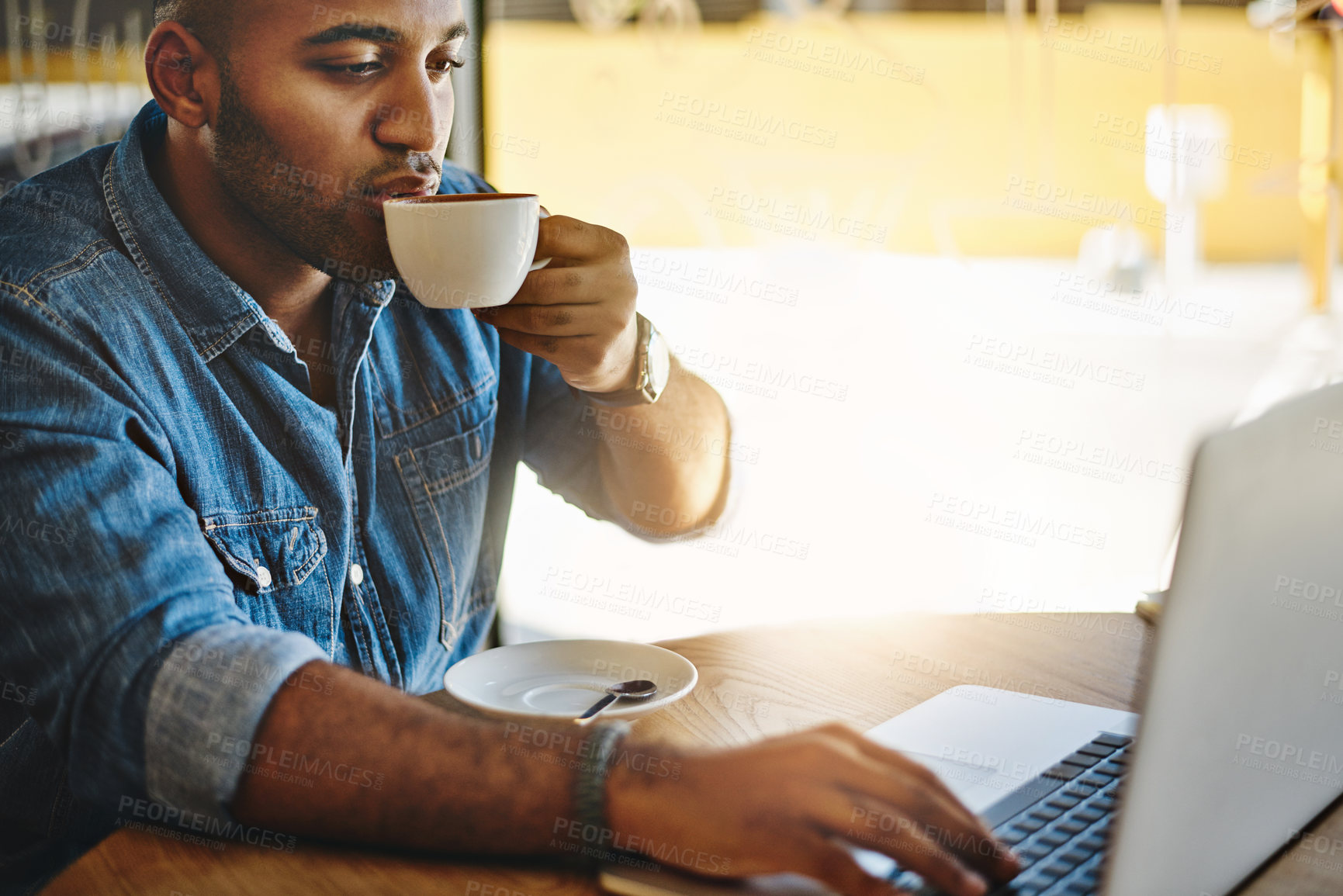 Buy stock photo Shot of a handsome young man drinking coffee while working working in a cafe