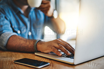 Buy stock photo Closeup shot of an unrecognizable man drinking coffee while working in a cafe