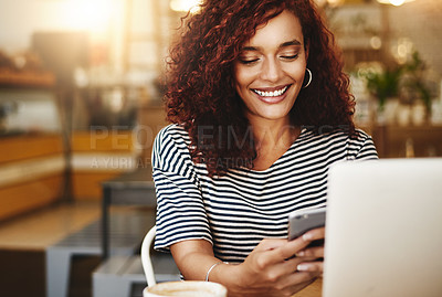 Buy stock photo Shot of an attractive young woman using a cellphone and laptop in a cafe
