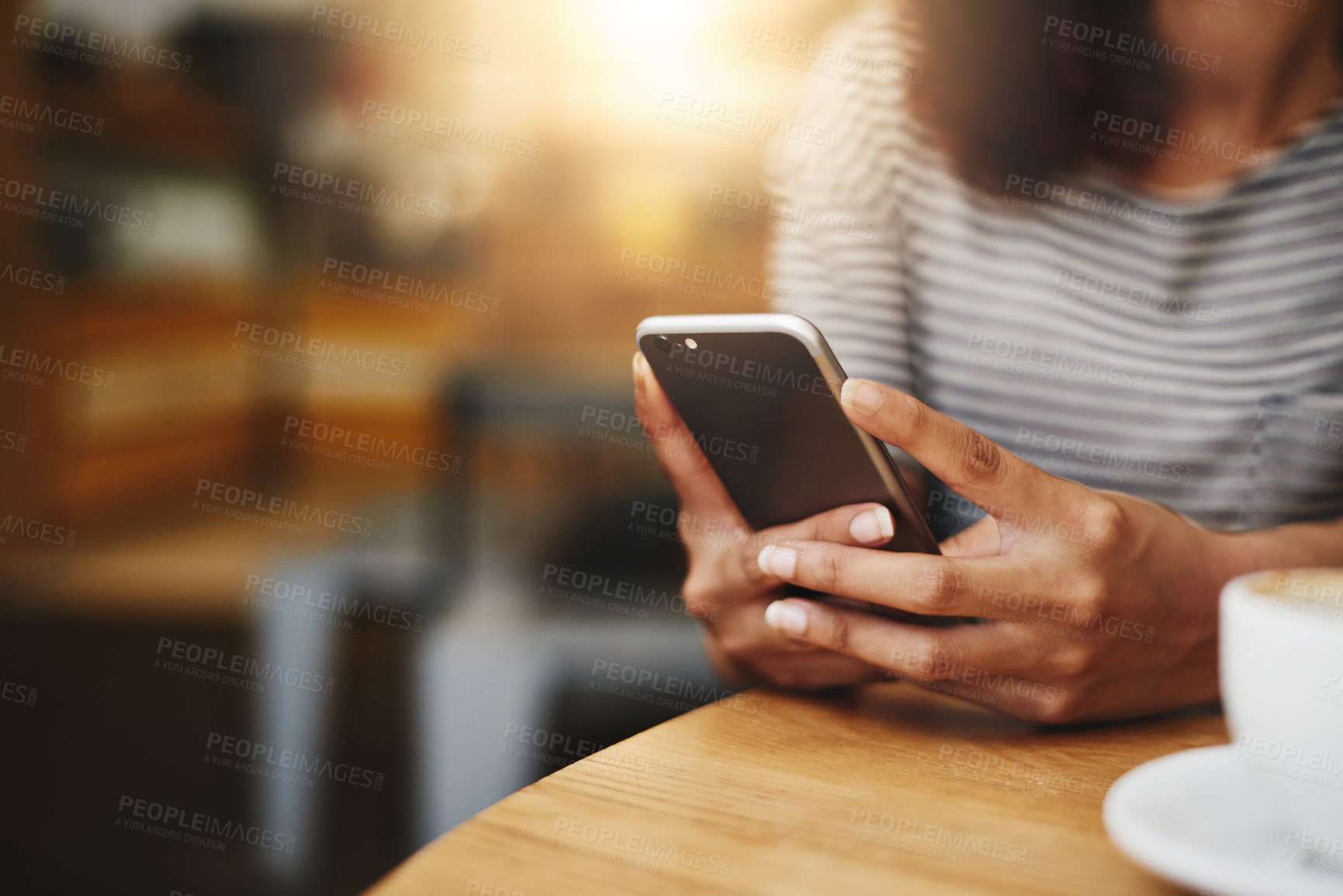 Buy stock photo Closeup shot of an unrecognizable woman using a cellphone in a cafe