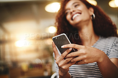 Buy stock photo Closeup shot of a young woman using a cellphone in a cafe