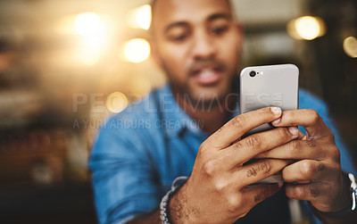 Buy stock photo Closeup shot of a young man using a cellphone in a cafe