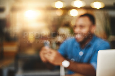 Buy stock photo Defocused shot of a young man using a cellphone in a cafe