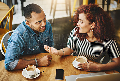 Buy stock photo High angle shot of a young couple working on a laptop while sitting in a coffee shop