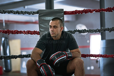 Buy stock photo Cropped shot of a young male athlete sitting in the corner of a boxing ring