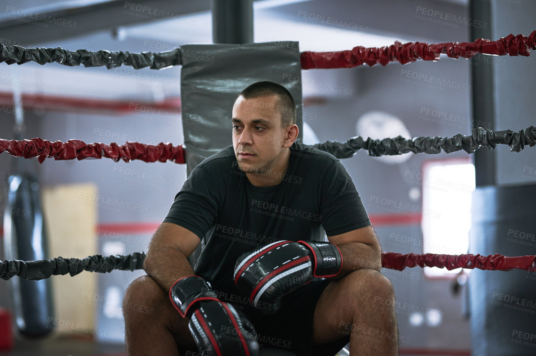 Buy stock photo Fitness, rest and man in ring for boxing, relax or thinking in gym after training for competition. Professional boxer, tired athlete or break for sport, workout or exercise with fatigue at fight club