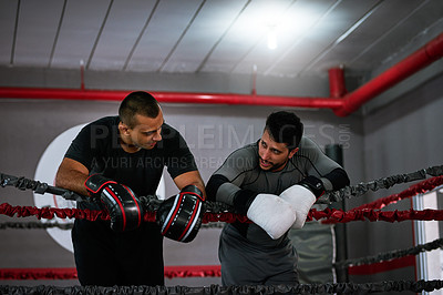 Buy stock photo Cropped shot of two young male athletes standing in a boxing ring after a sparring session