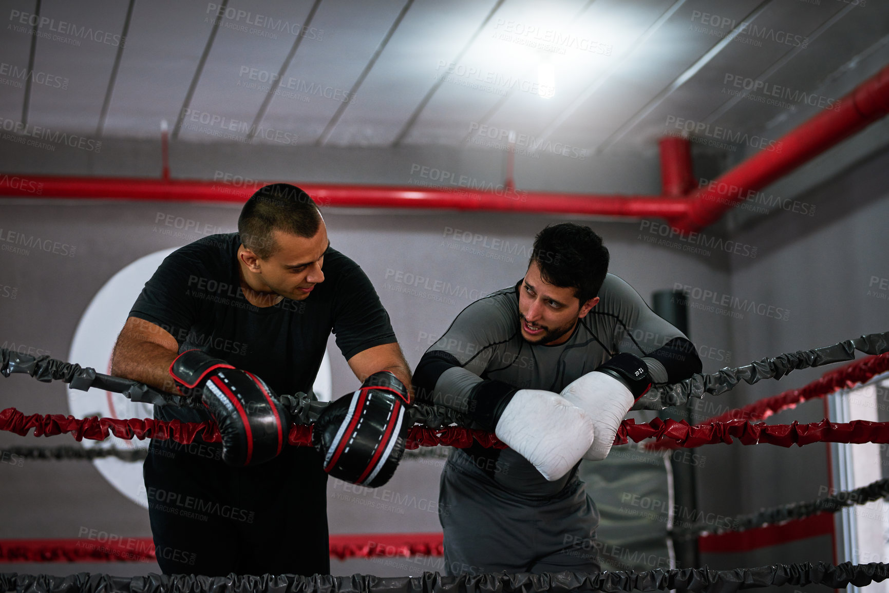 Buy stock photo Cropped shot of two young male athletes standing in a boxing ring after a sparring session