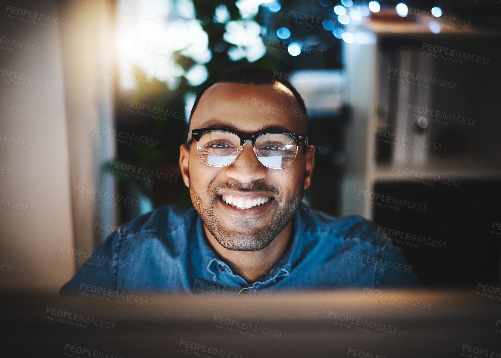 Buy stock photo Portrait of a young businessman using a computer during a late night at work in a modern office