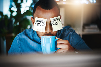 Buy stock photo Shot of a young businessman working late at work with sticky notes covering his eyes and drinking coffee