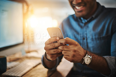 Buy stock photo Cropped shot of a young businessman using a mobile phone during a late night at work
