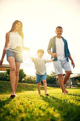 Buy stock photo Shot of a young family spending the day in the backyard