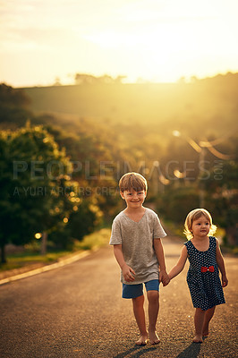 Buy stock photo Shot of an adorable little brother and sister taking a walk down the road together outside