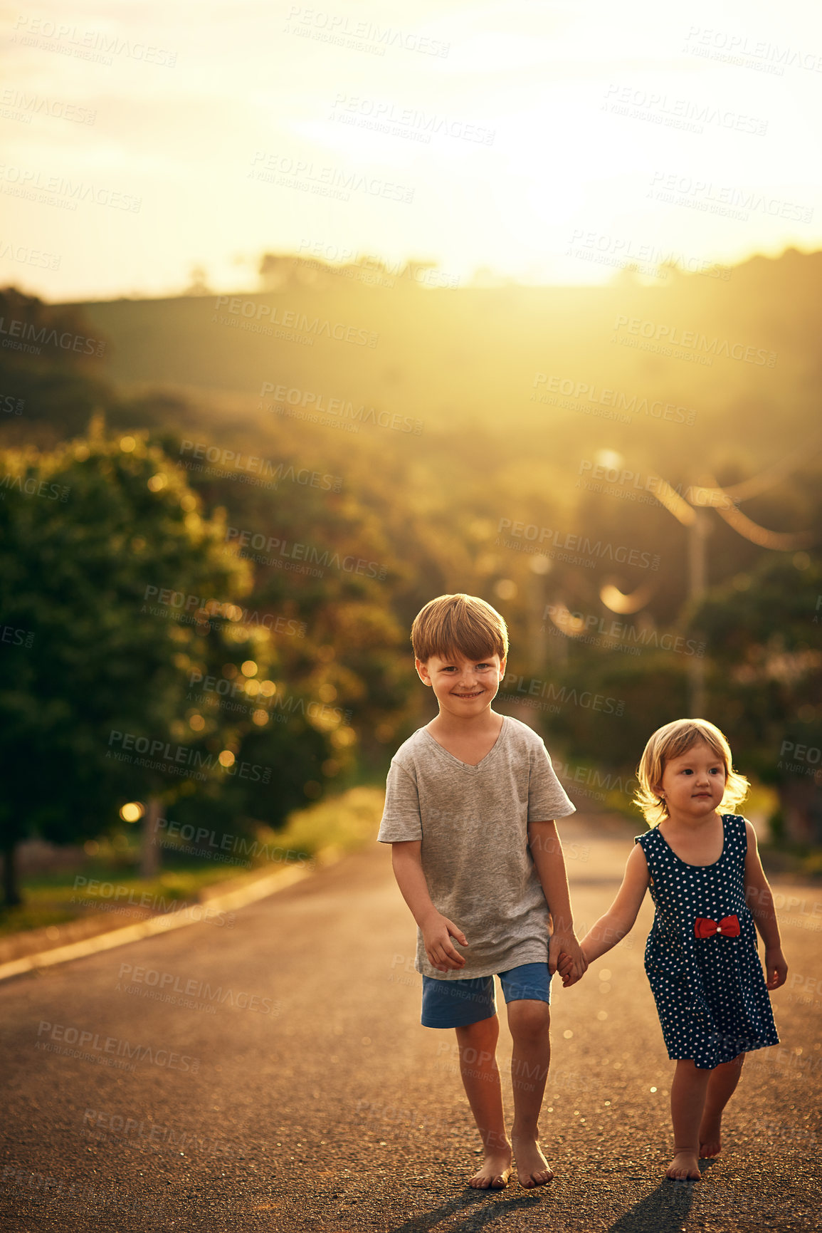 Buy stock photo Shot of an adorable little brother and sister taking a walk down the road together outside