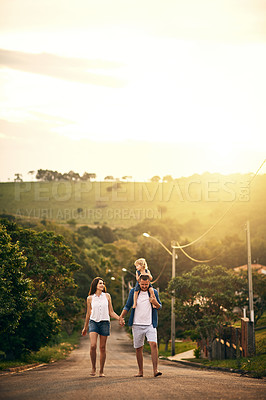 Buy stock photo Shot of a young family taking a walk down the road outside