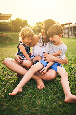 Buy stock photo Mother, happy children or hug playing on grass for fun bonding in summer outside a house in nature. Funny mom hugging playful kids siblings on garden playground with happiness of family together