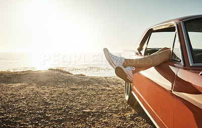 Buy stock photo Cropped shot of a woman's legs hanging out a car window while on a road trip