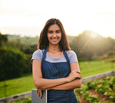 Buy stock photo Cropped portrait of an attractive young woman standing with her arms folded on her farm