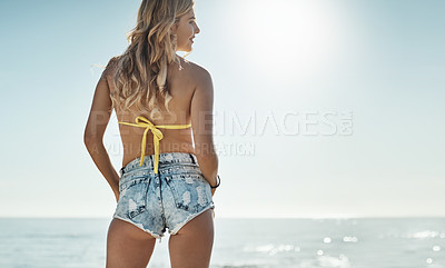 Buy stock photo Rearview shot of an attractive young woman enjoying her day on the beach